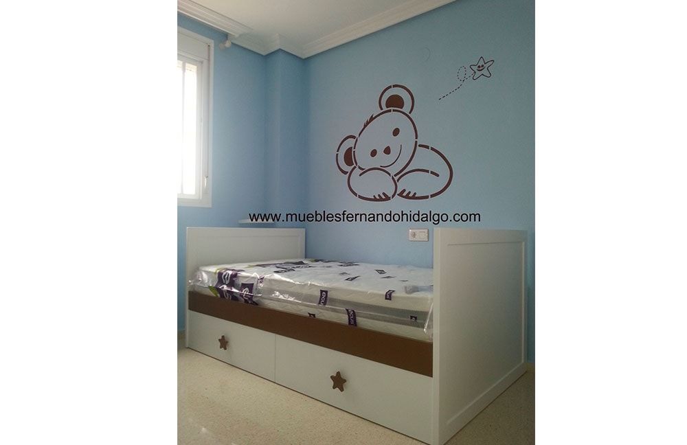 Un dormitorio con una cama y un osito de peluche en la pared.