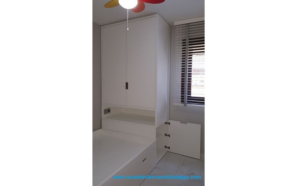 Un dormitorio con una cama y un ventilador de techo.