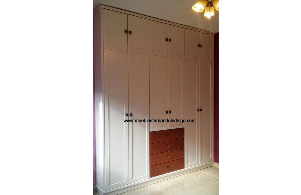 Un gran armario con muchas puertas y cajones.
