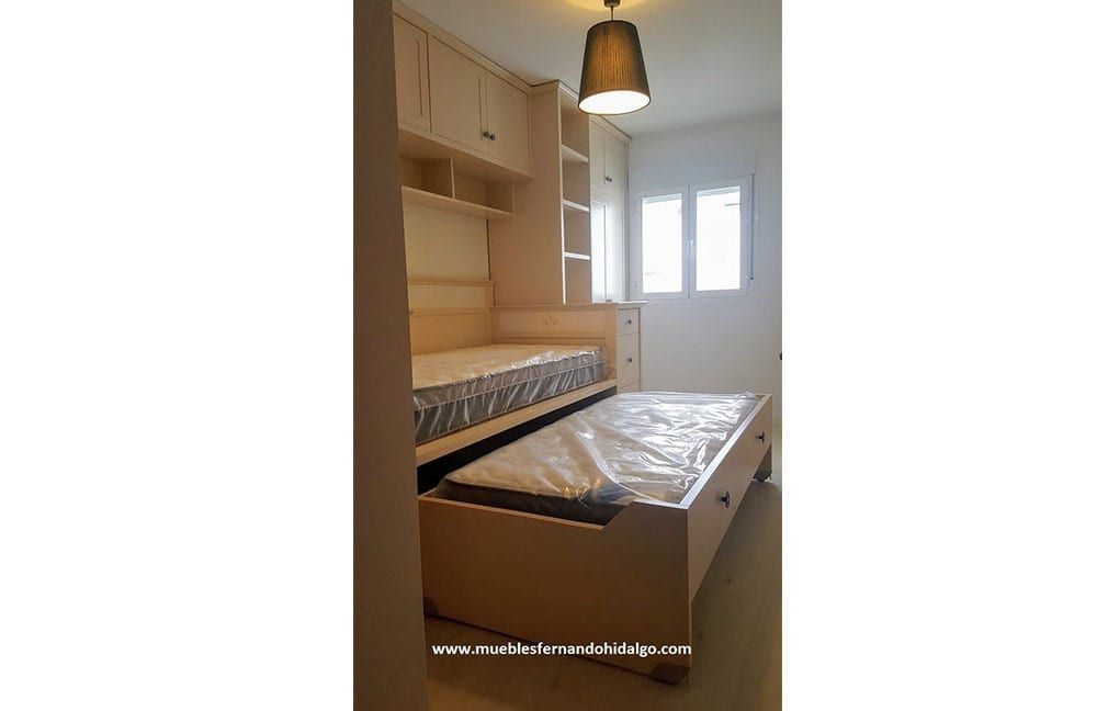 Un dormitorio con una cama que está sacada de la pared.