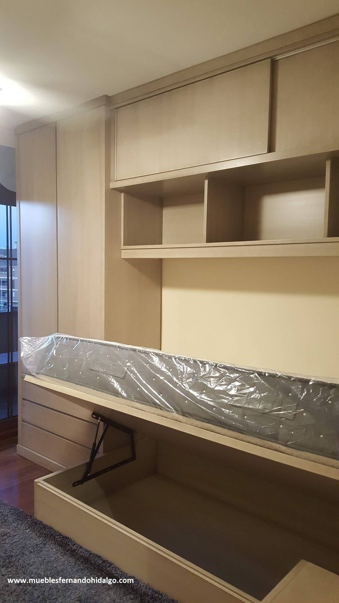 Un dormitorio con cama, cómoda, estantes y cajones.