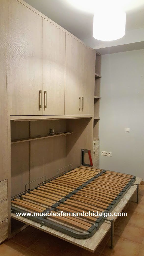 Una cama está empotrada en una pared de un dormitorio.