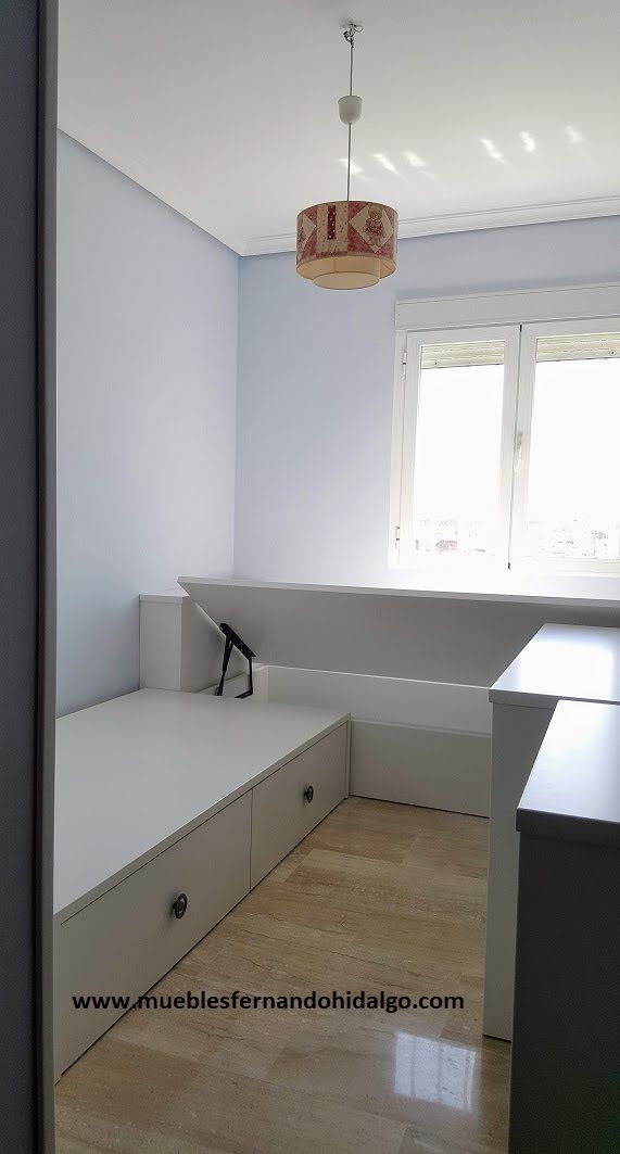 Un dormitorio con una cama y una ventana con una lámpara colgando del techo.