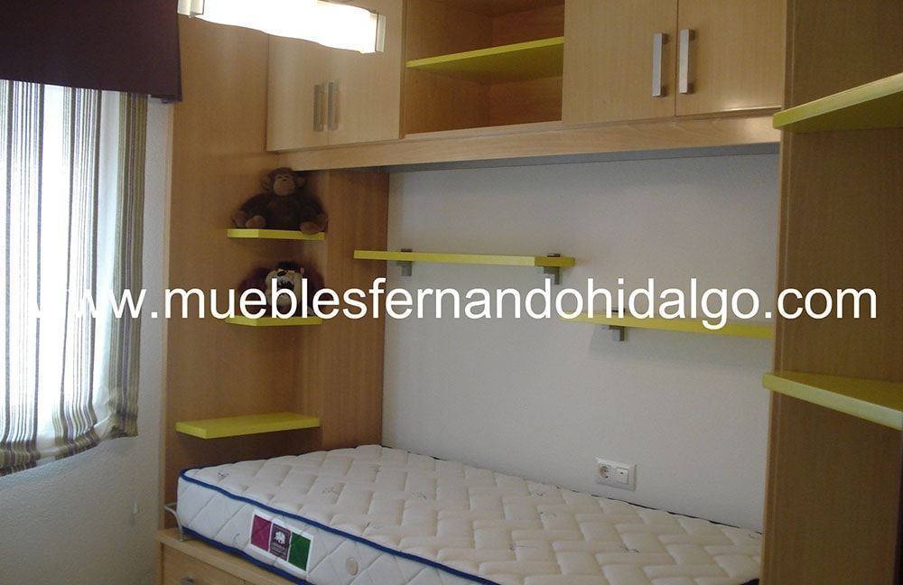 Un dormitorio con colchón y estanterías y la web www.mueblesfernandohidalgo.com