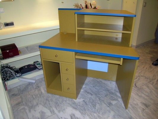 Un escritorio de madera con tapa azul y cajones.