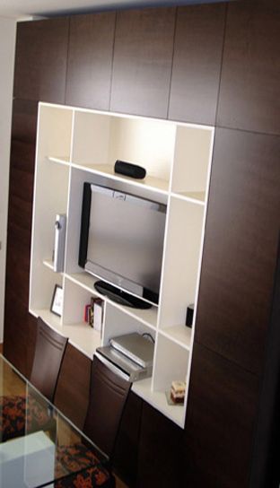Un centro de entretenimiento montado en la pared con un televisor de pantalla plana.