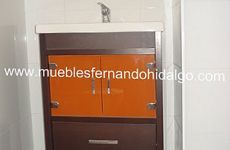 Un tocador de baño con gabinetes de color naranja y un lavabo.