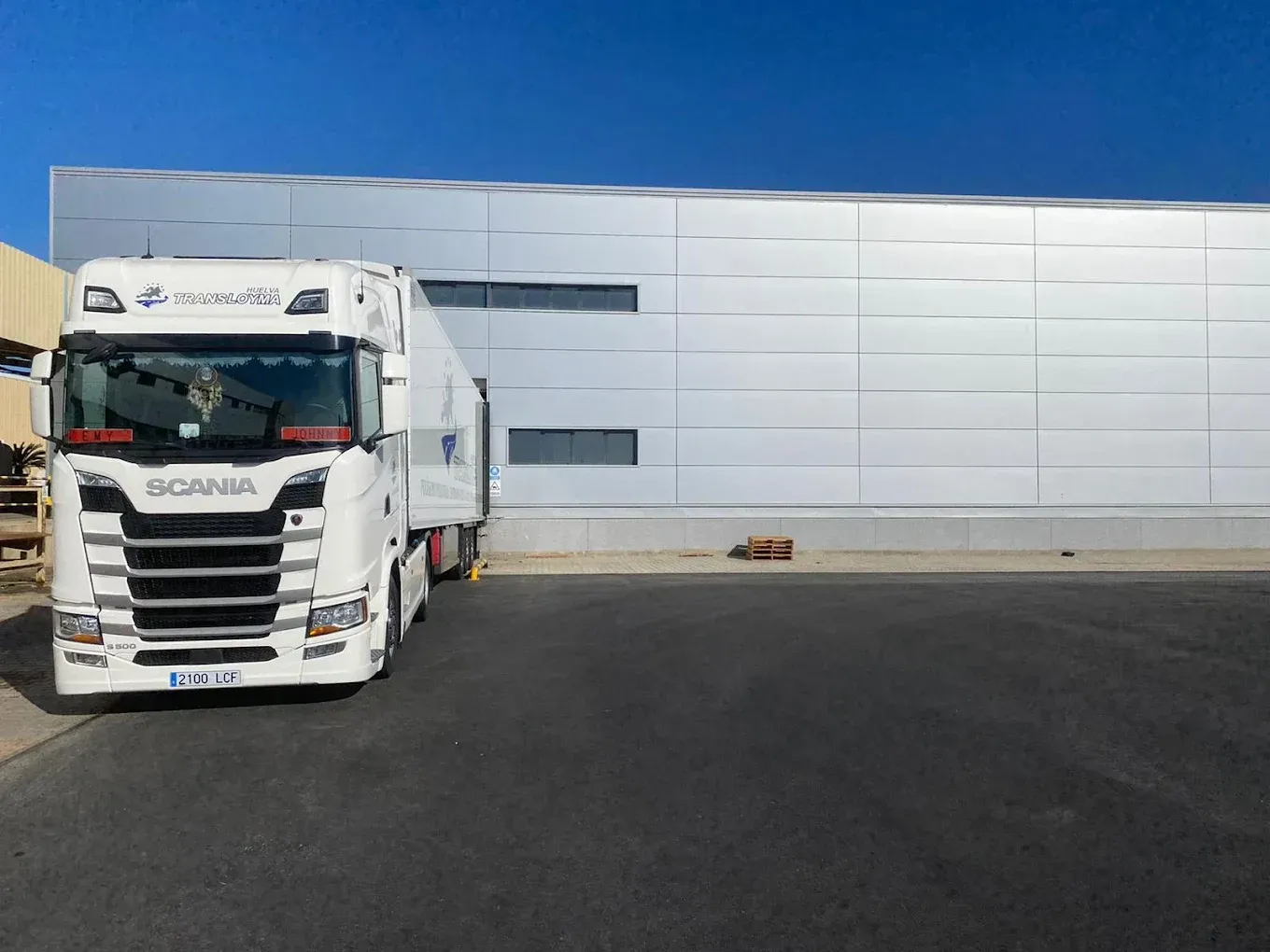 Repartidor con cajas y cliente firmando papeleo.