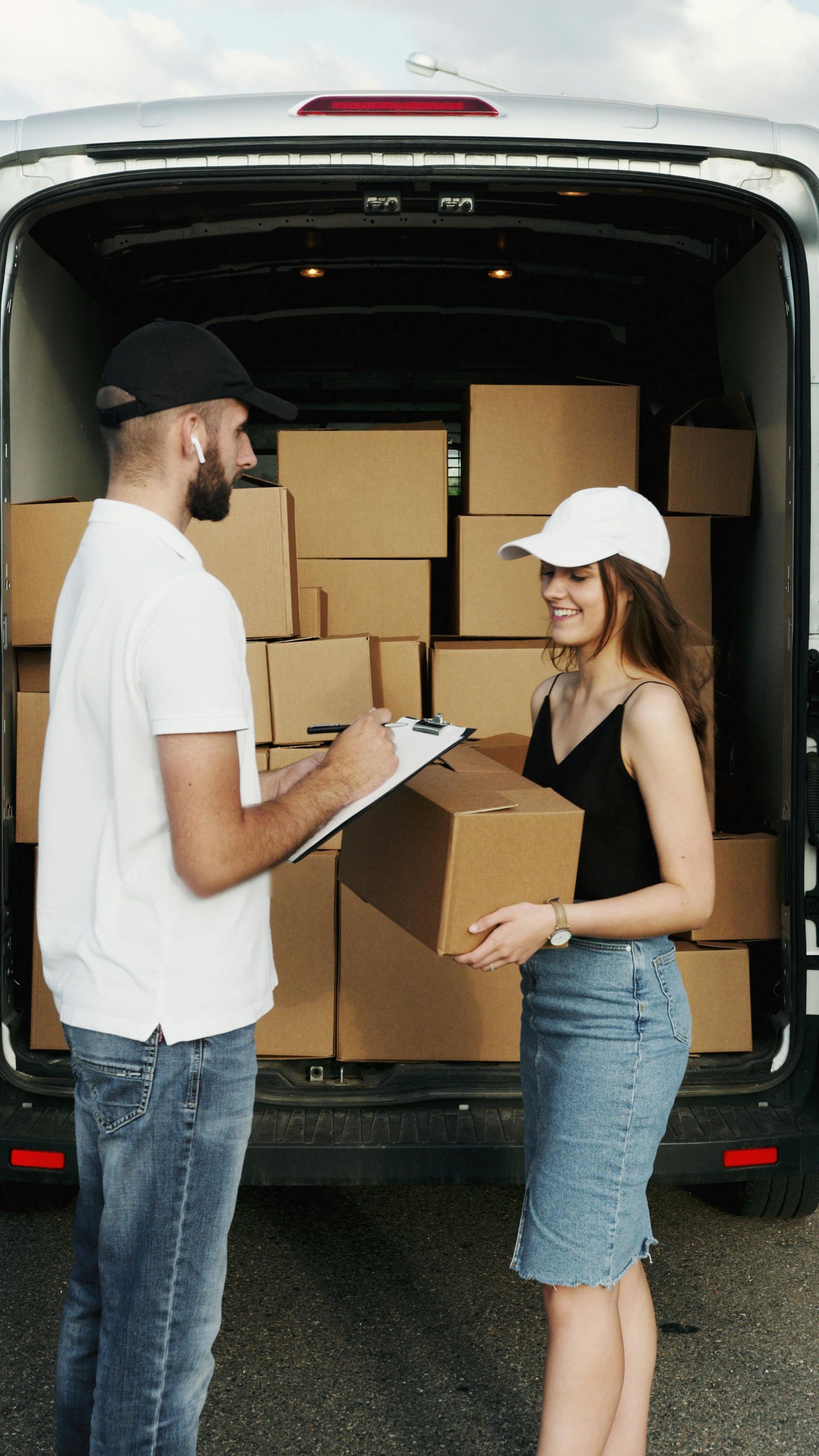 Repartidor con cajas y cliente firmando papeleo.