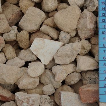 Se mide una pila de rocas con una cinta métrica azul.