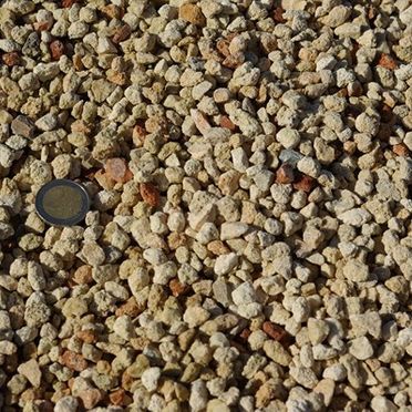 Un montón de grava con una moneda encima.