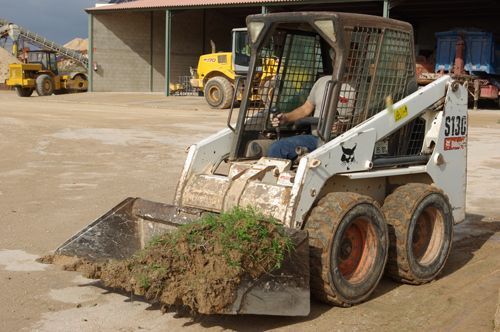 Un hombre conduce una minicargadora Bobcat