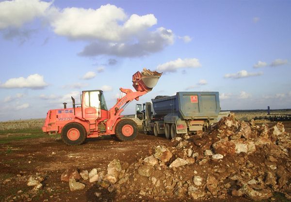 Una excavadora está cargando tierra en un camión volquete