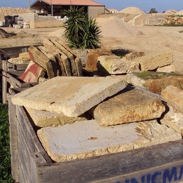 Una caja de madera llena de piedras en un campo.