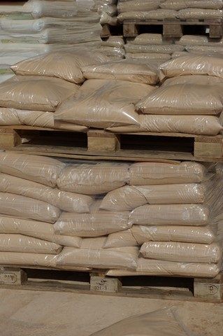 Un montón de bolsas apiladas una encima de otra sobre paletas de madera.