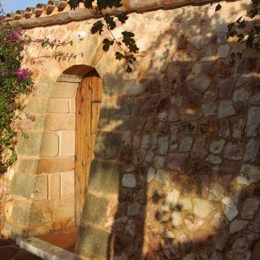 Un muro de piedra con una puerta de madera.
