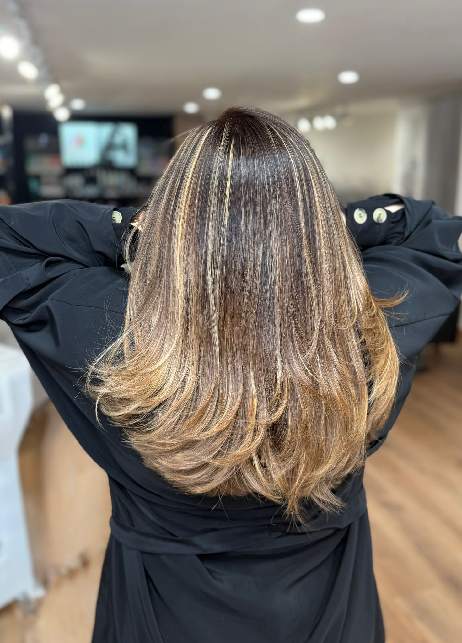 Mujer con cabello largo en capas, raíces oscuras