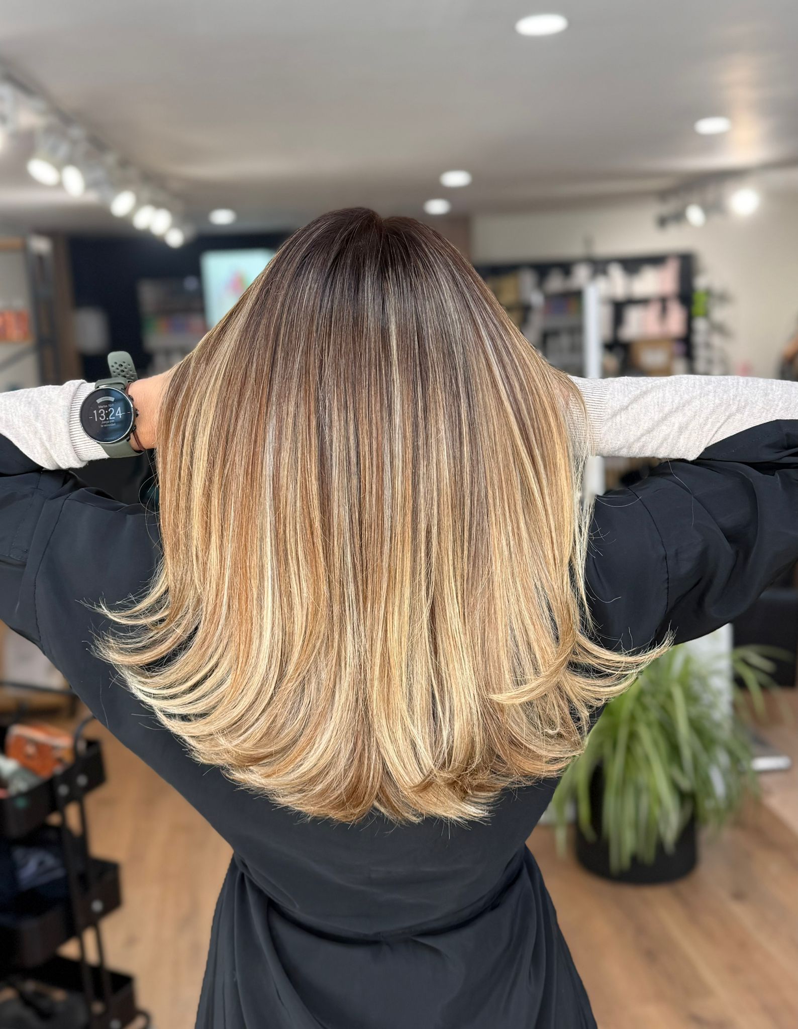 Cabello de mujer, con raíces oscuras que se funden con puntas castaño claro y rubias. 