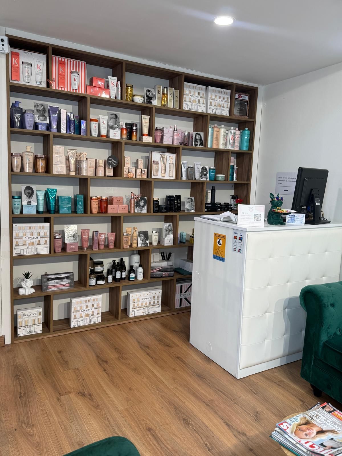 Exhibición de salón con productos en estantes y un mostrador de recepción blanco. 