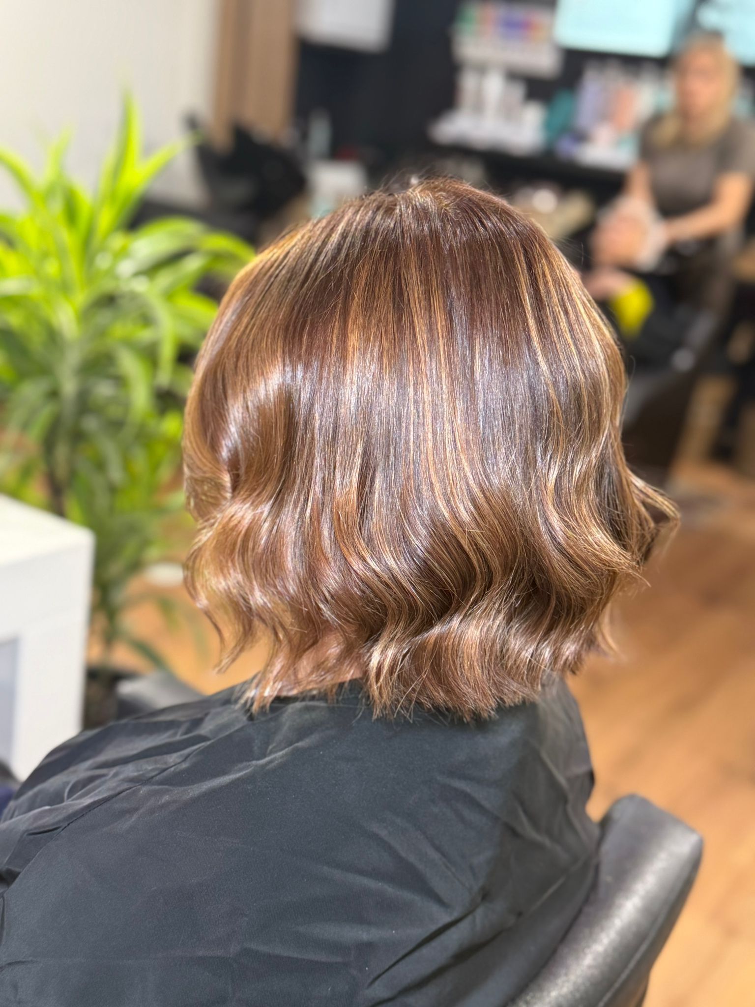 Peinado bob ondulado castaño en salón.