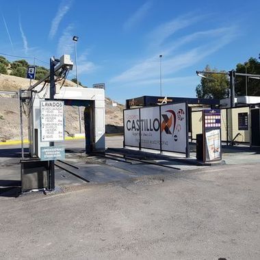 Entrada del restaurante Castillo con carta, quiosco al aire libre y cielo azul despejado
