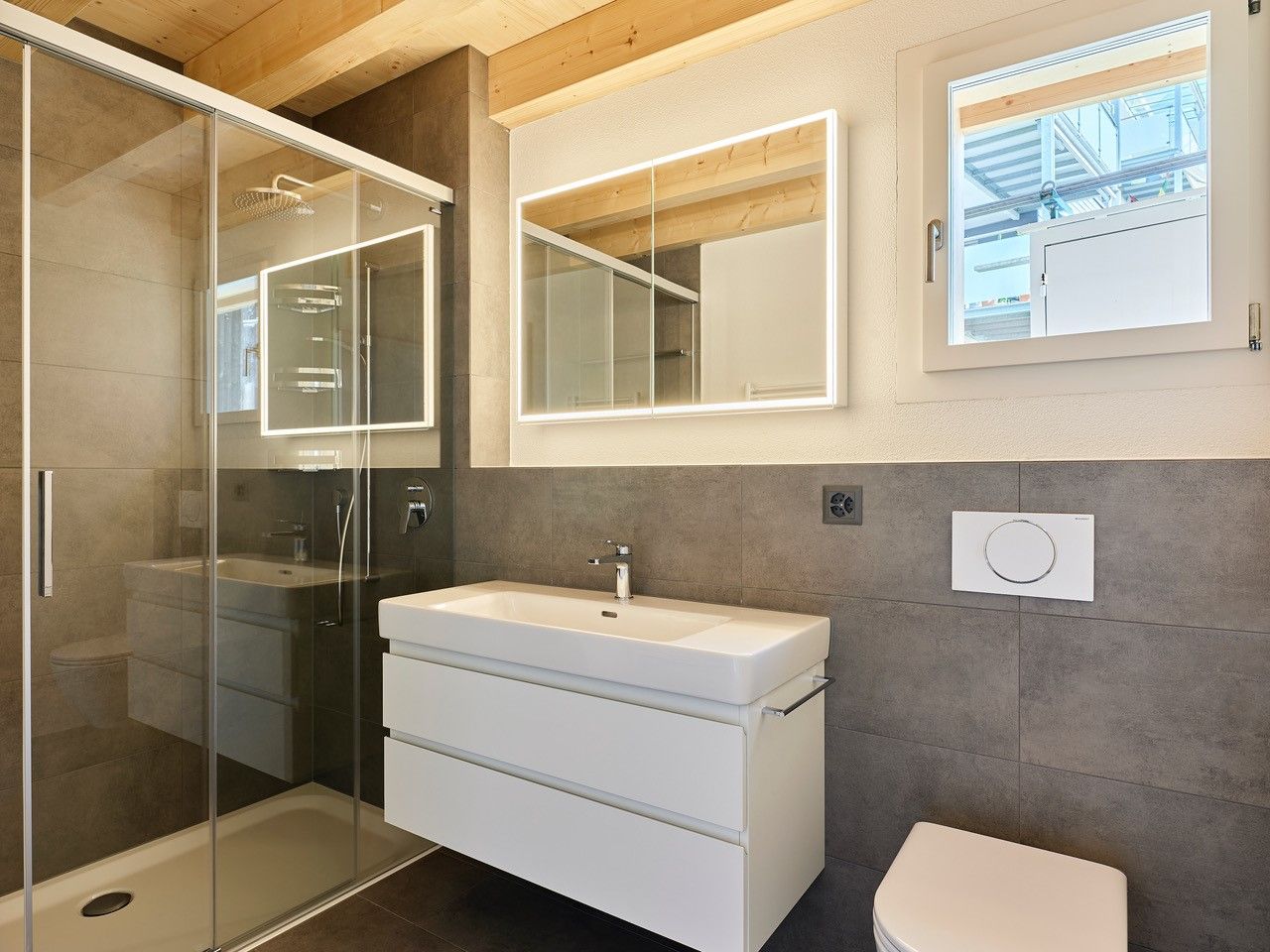 Ein Badezimmer mit Waschbecken, Toilette, Dusche und Spiegel.