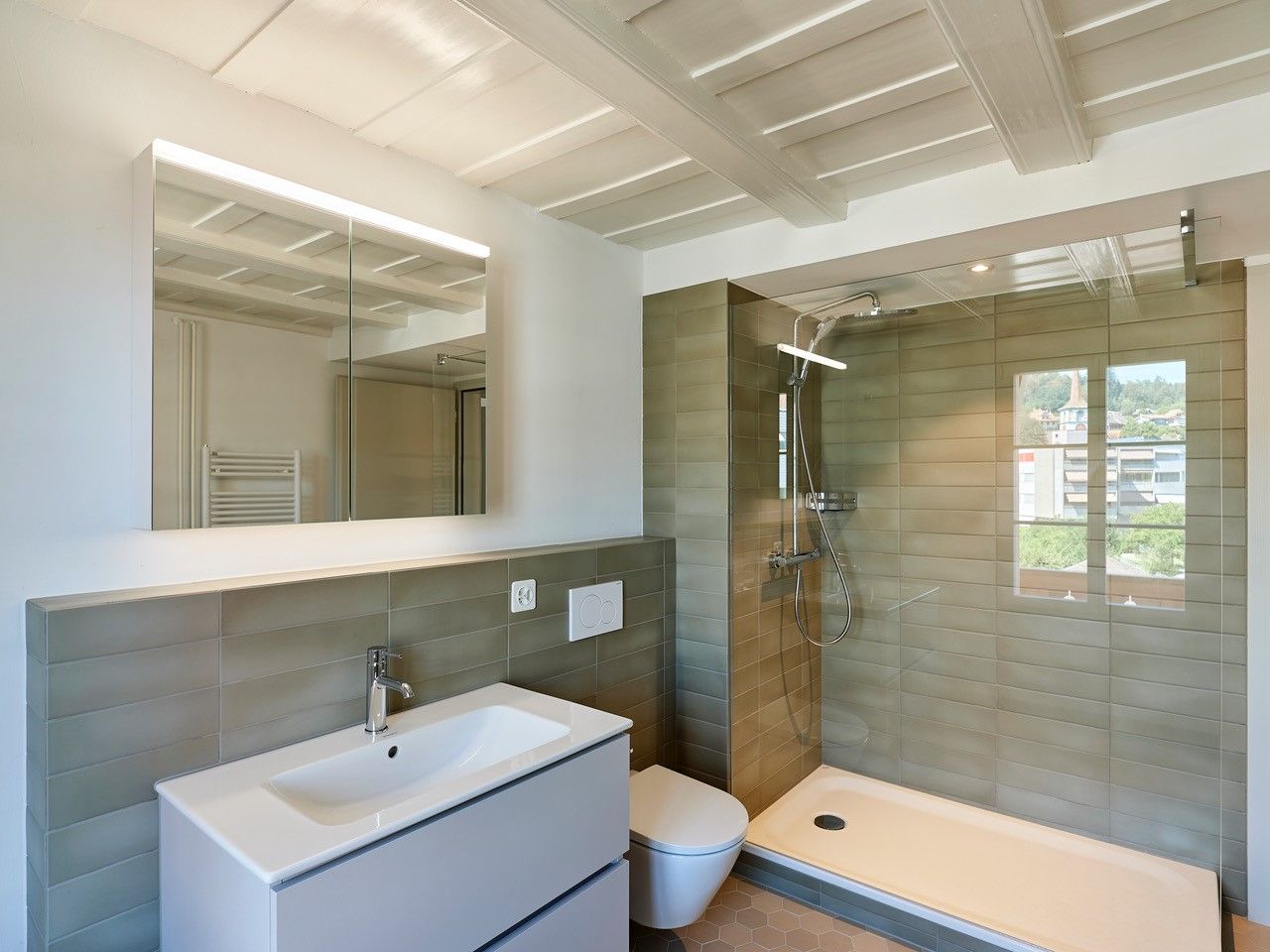 Ein Badezimmer mit Waschbecken, Toilette und ebenerdiger Dusche.