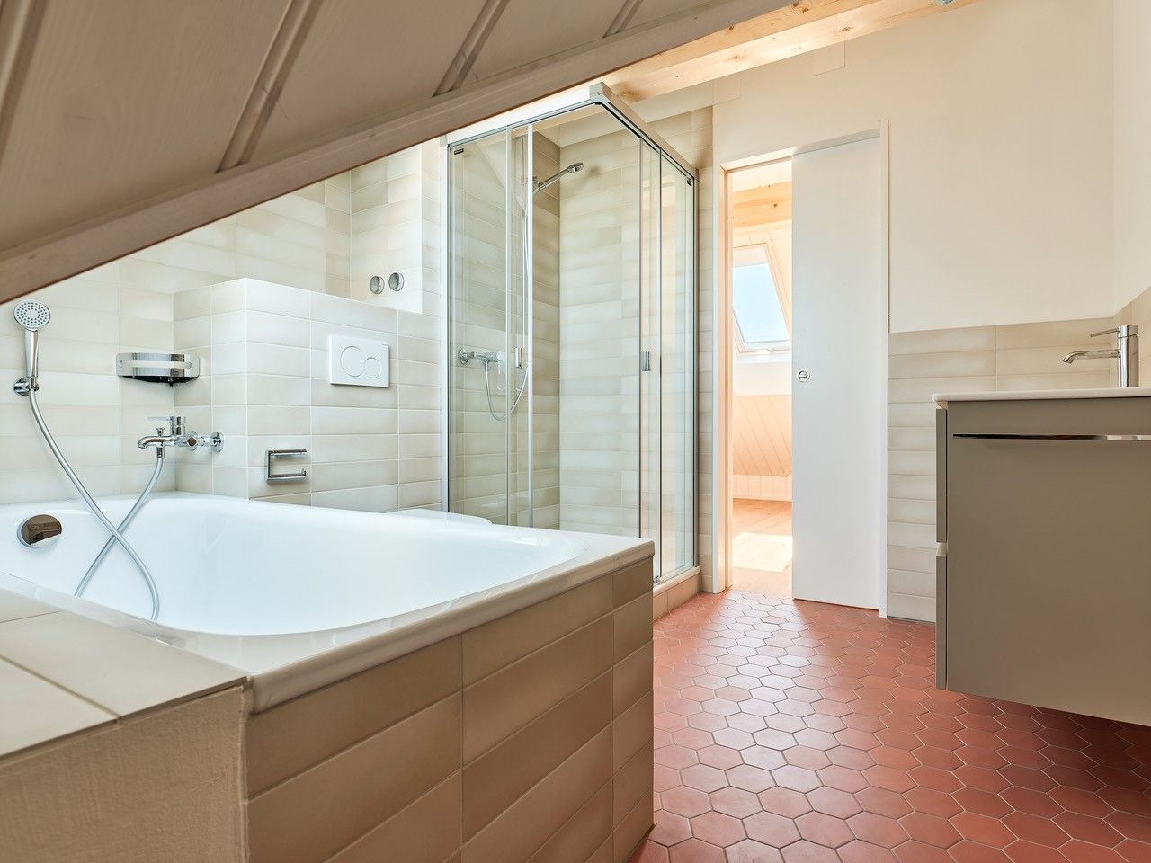 Ein Badezimmer mit Badewanne und ebenerdiger Dusche.