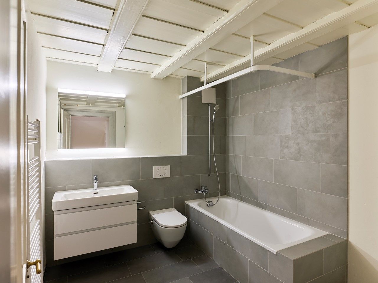 Ein Badezimmer mit Badewanne, Toilette, Waschbecken und Spiegel.