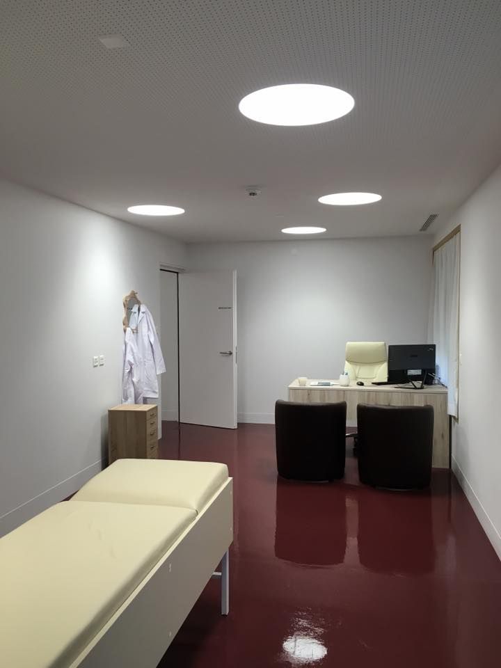 Un cabinet médical avec un lit et un bureau