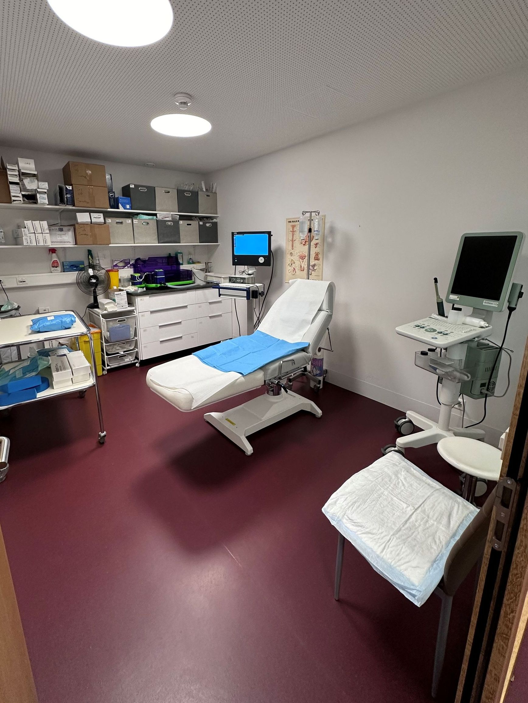 Une chambre d'hôpital avec un lit et un moniteur sur le mur.