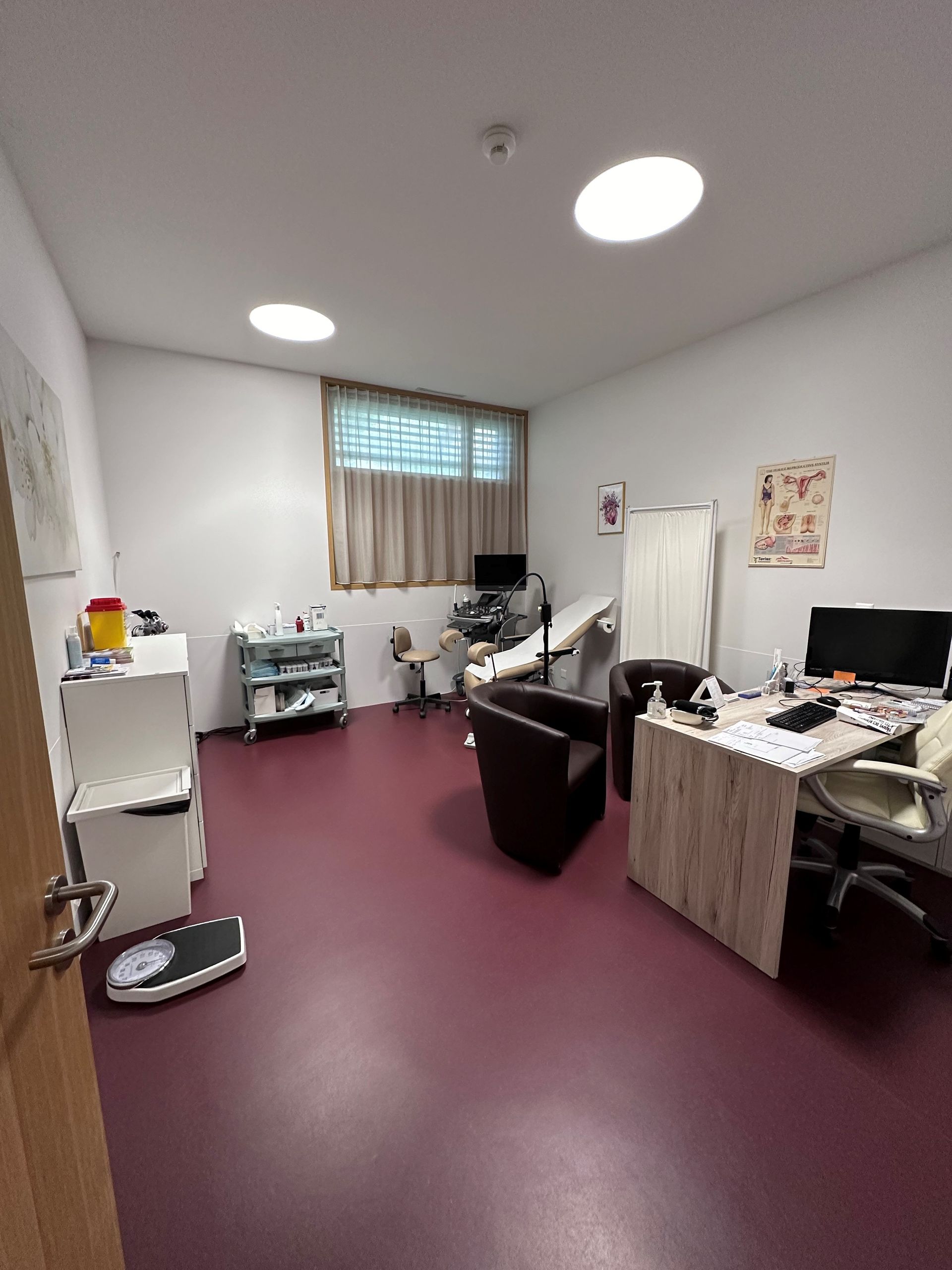 Un cabinet médical avec deux chaises, un bureau et un appareil à ultrasons.