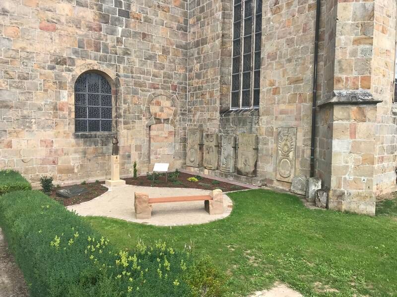 Ein Steingebäude mit einer Bank davor.