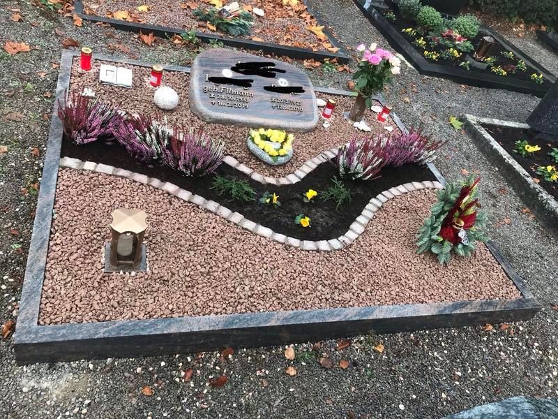 Ein Grab mit Blumen und Kerzen darauf