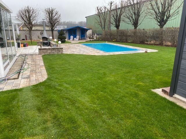 Im Hinterhof eines Hauses befindet sich ein großer Swimmingpool.