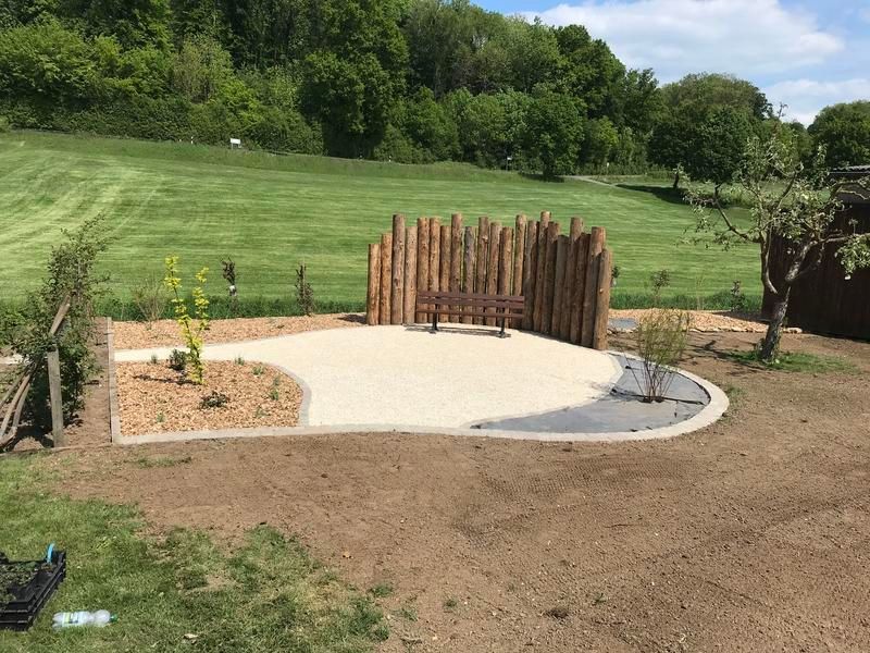 Eine Terrasse mit einer Bank inmitten eines Feldes.