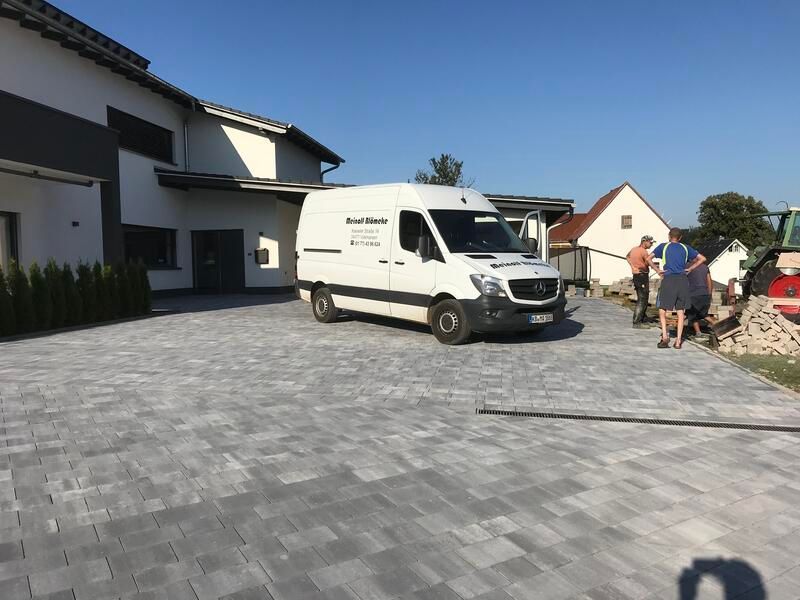 Ein weißer Lieferwagen steht vor einem Haus