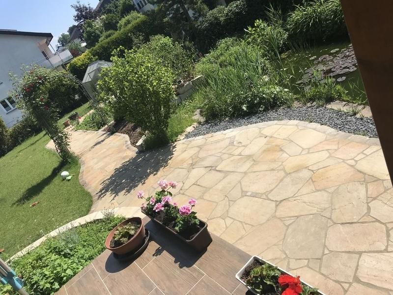 Eine Terrasse mit Topfpflanzen und Blumen darauf