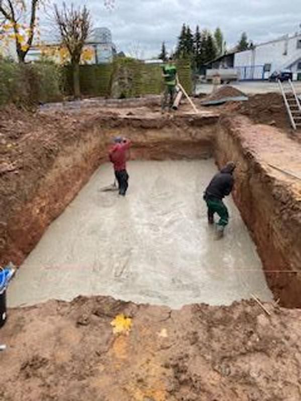 Eine Gruppe von Leuten arbeitet an einem großen Loch im Boden.