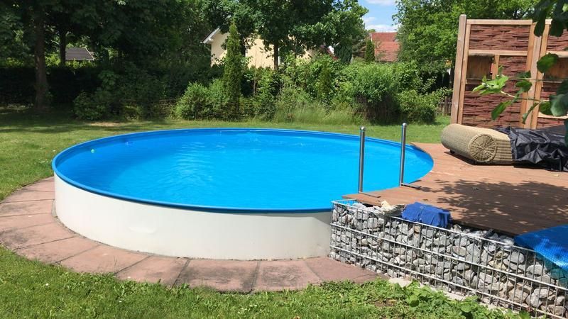 Inmitten eines üppig grünen Gartens befindet sich ein kleiner Swimmingpool.