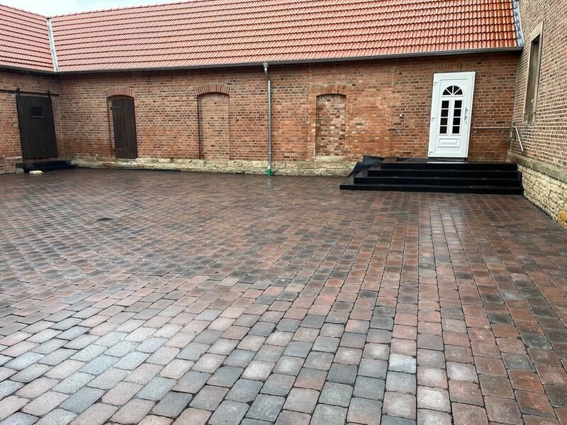 Eine gemauerte Auffahrt vor einem Backsteingebäude