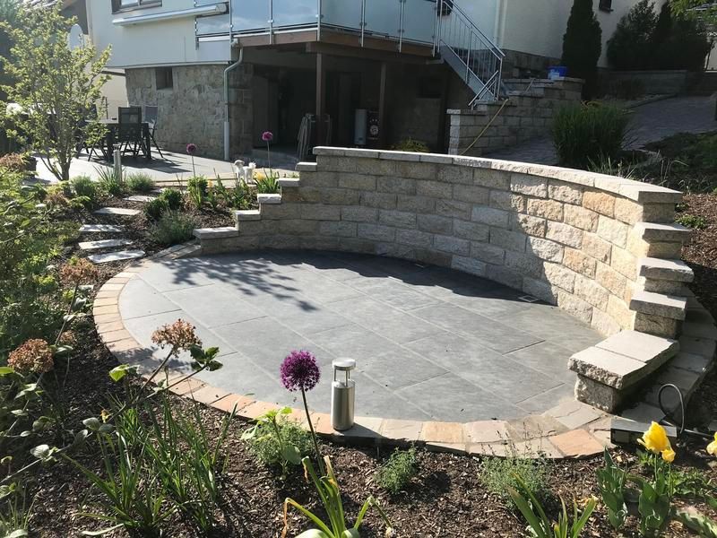 Mitten im Garten steht eine Backsteinmauer.