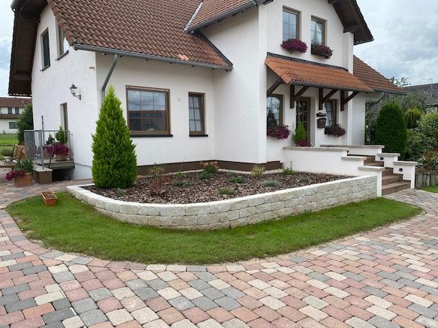 Ein weißes Haus mit einer gepflasterten Auffahrt davor