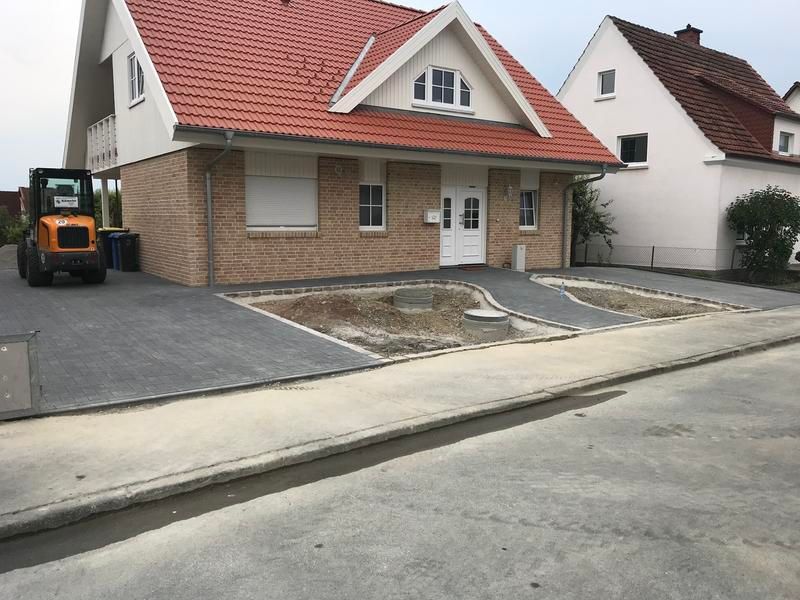 Ein Traktor steht vor einem Backsteinhaus