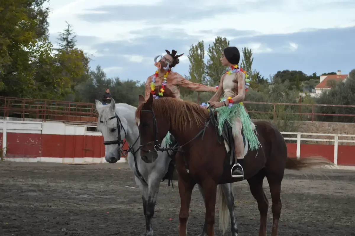 Dos personas disfrazadas posan junto a un caballo. Una vestida de extraterrestre con un bastón en la mano