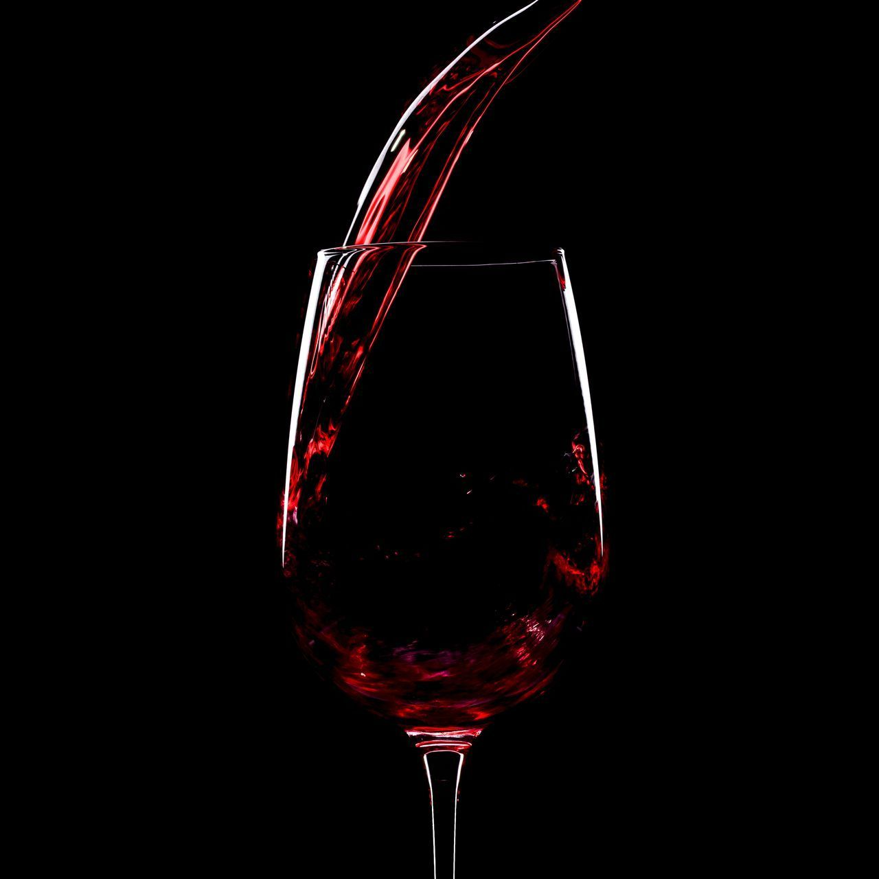 Un verre qui se remplit de vin rouge