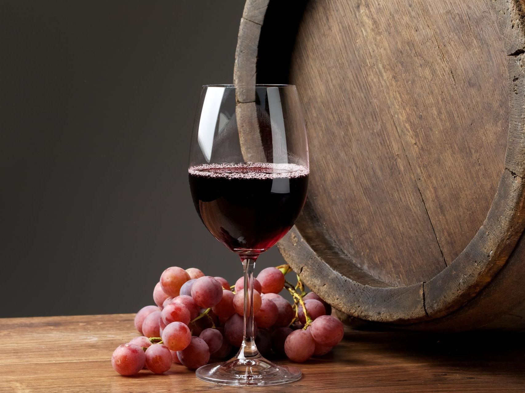 Un verre de vin, du raisin et un tonneau