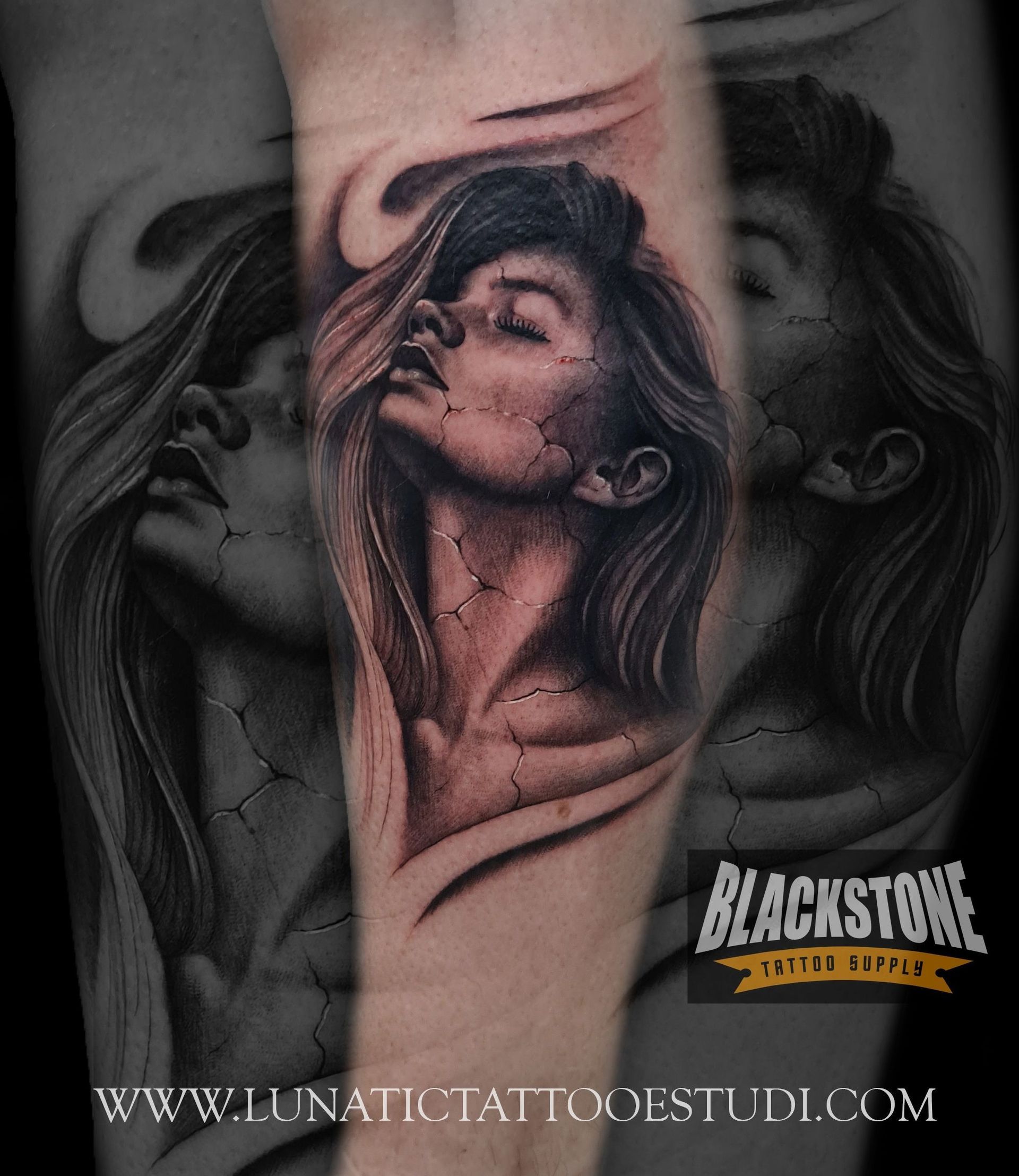 Tatuaje en blanco y negro de un rostro con textura agrietada, similar a la piedra, sobre un fondo de líneas abstractas onduladas en un brazo.