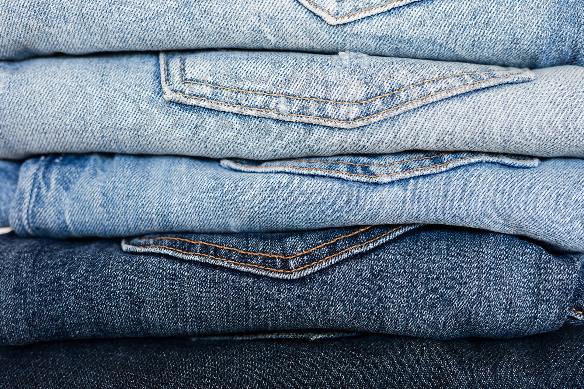 Pila de pantalones vaqueros doblados en varios tonos de azul.