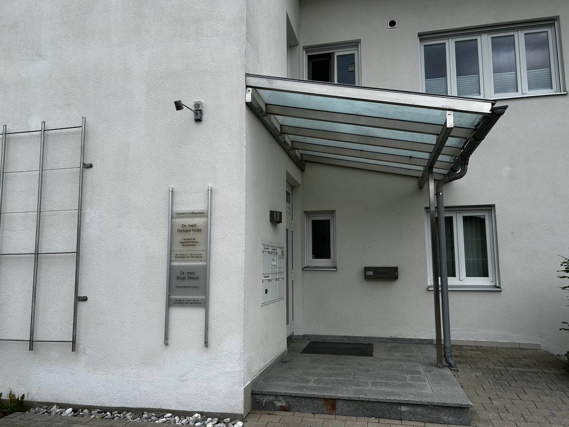 Weiße Gebäude mit einem überdachten Eingang